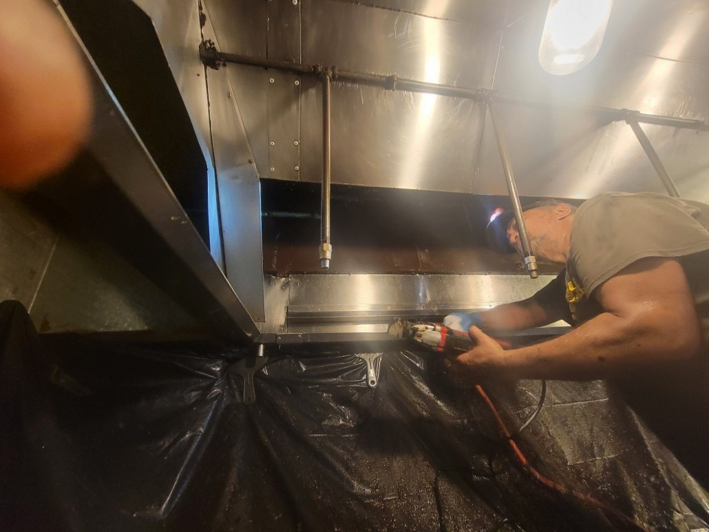 Oahu hood cleaning expert cleaning a restaurant exhaust hood.