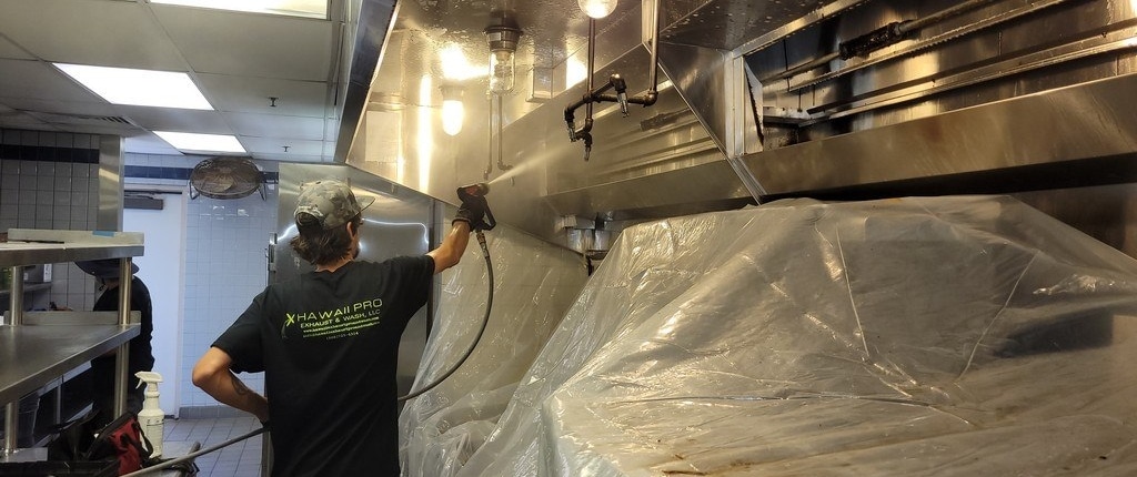 Oahu hood cleaning service pro degreasing a kitchen exhaust hood. We also provide baffle filter replacement, exhaust fan maintenance, rooftop grease containment, and much more.